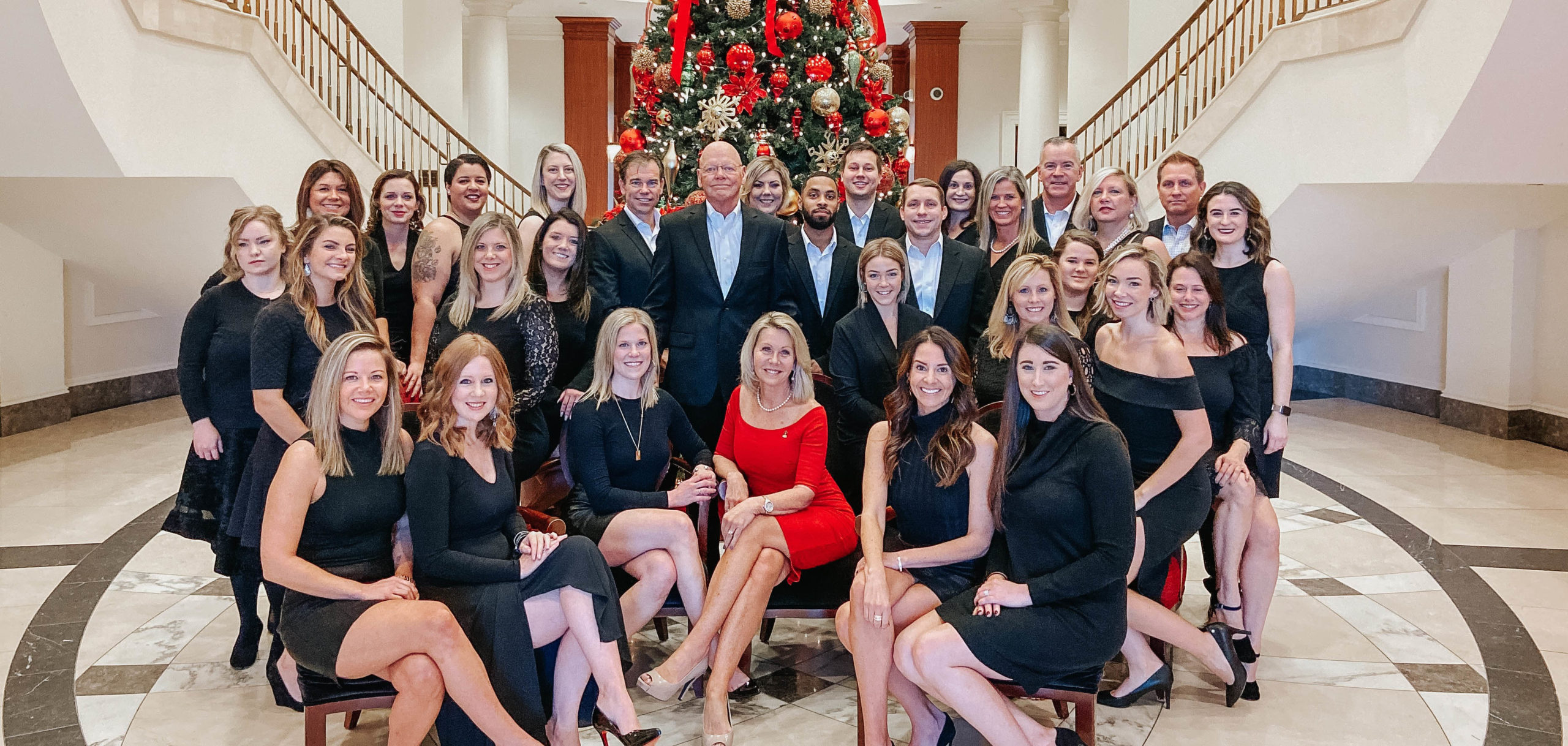 The Rachel Kendall Team in front of a Christmas tree