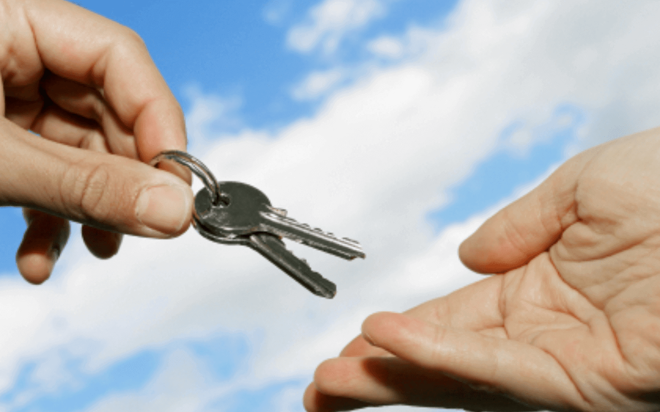 Hands passing off house keys